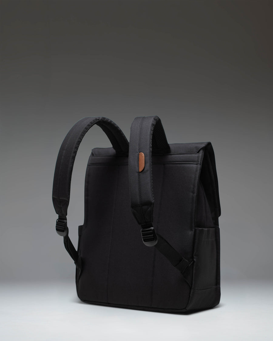 Herschel Supply Co. City Backpack in classic black, showing a sleek, minimalist design with a single strap closure and a front storage sleeve.