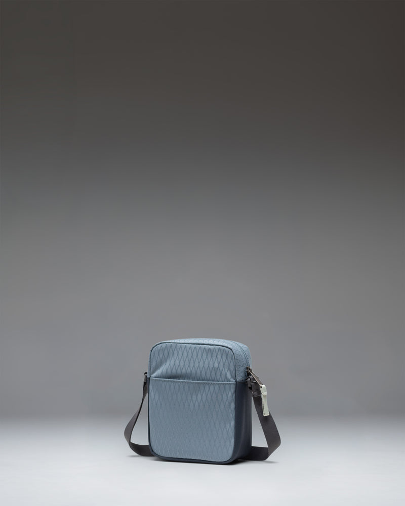 Herschel Heritage Crossbody bag in Blue Mirage Diamond/Sea Storm worn over the shoulder to show size and fit.