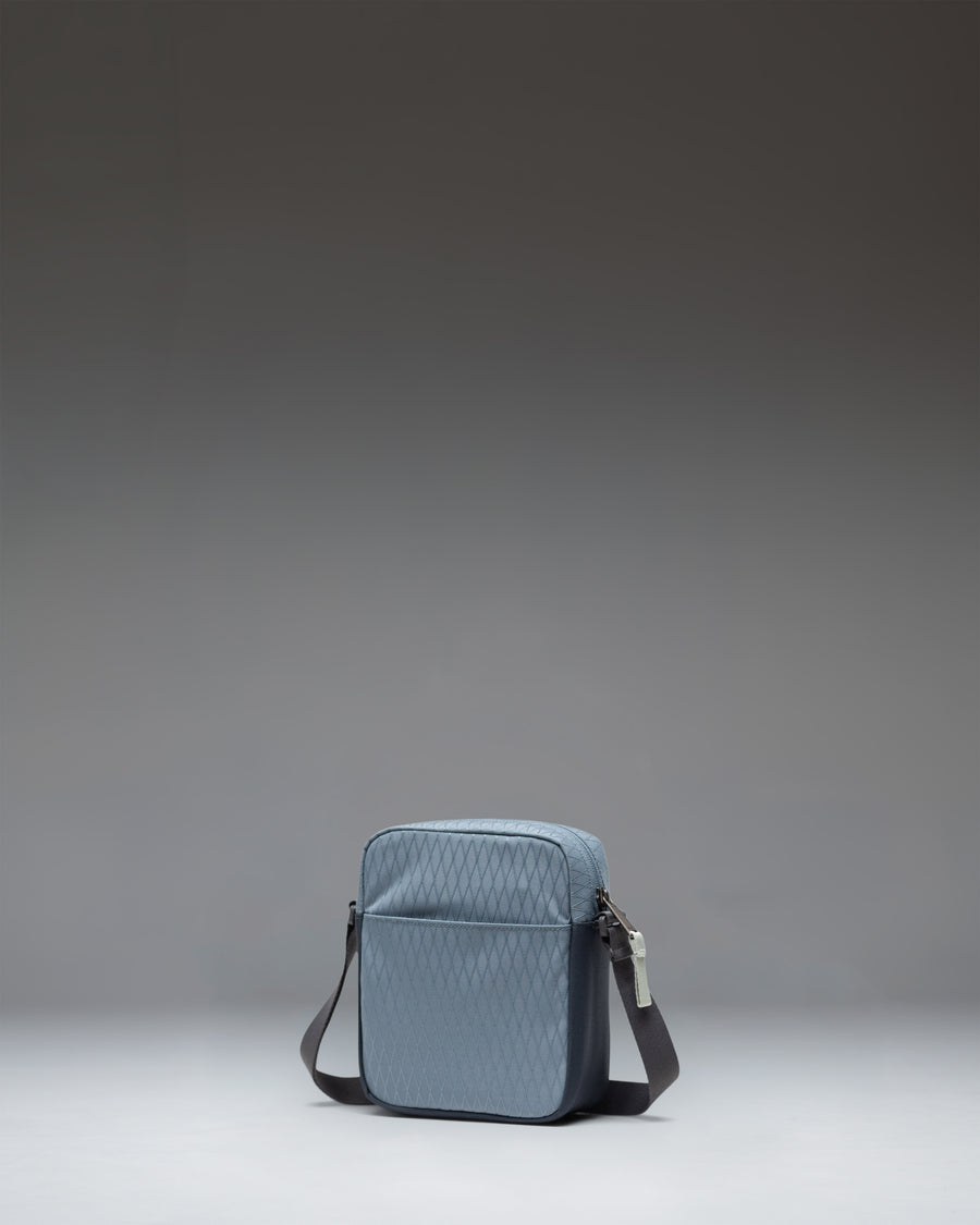 Herschel Heritage Crossbody bag in Blue Mirage Diamond/Sea Storm worn over the shoulder to show size and fit.