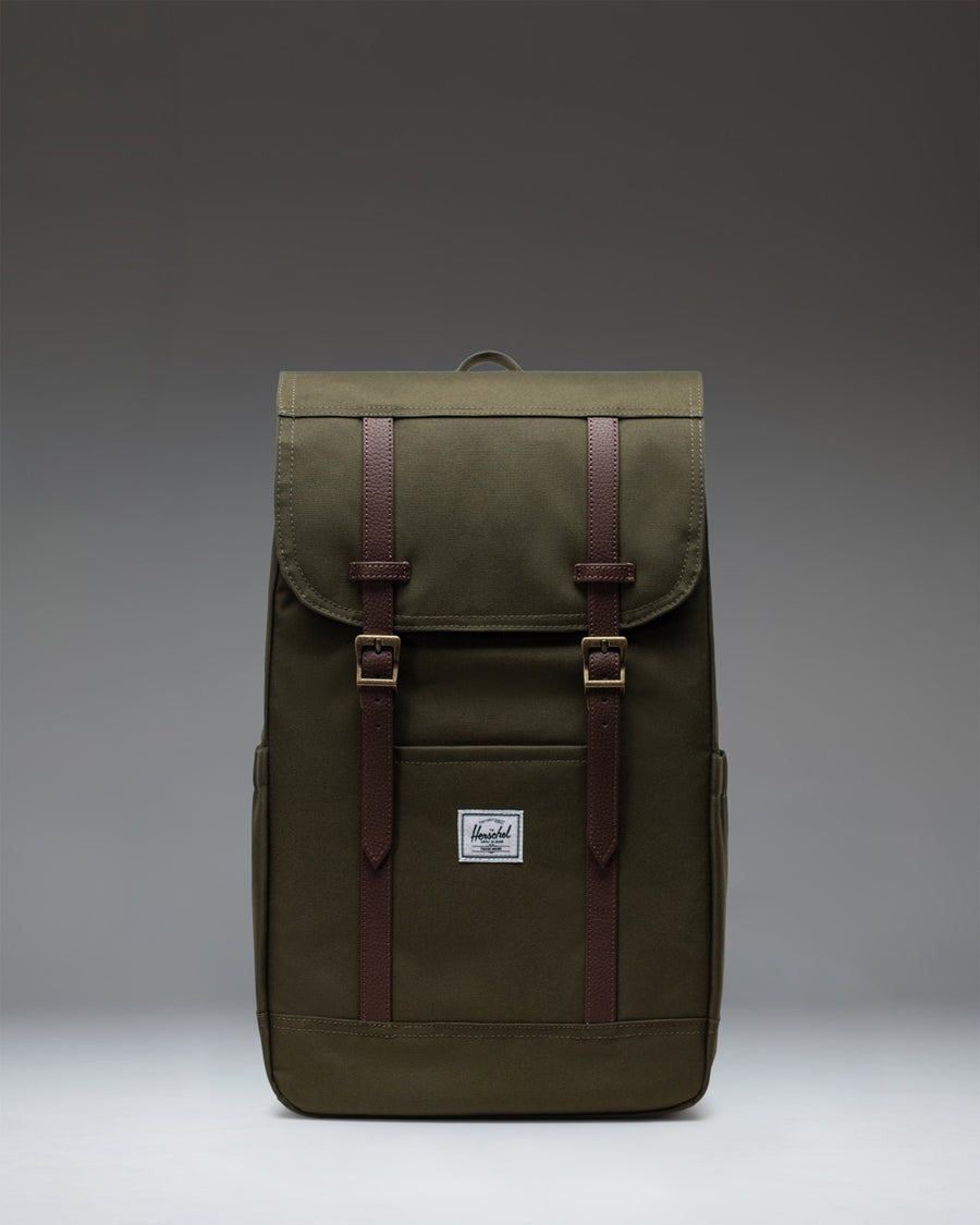 Herschel Retreat Backpack in Ivy Green with brown strap details and a classic woven label on the front.