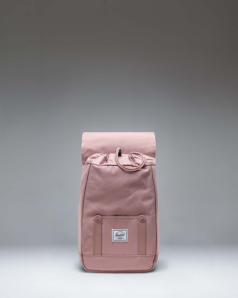 Herschel Retreat Mini Backpack in Ash Rose featuring a drawcord closure and magnet-fastened straps with buckles.