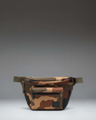 Herschel Supply Co Pop Quiz Hip Pack in Woodland Camo featuring a front zippered pocket and adjustable webbing strap.