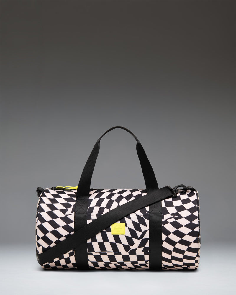Herschel Supply Co. Classic Duffle Little Herschel in Warp Check pattern, a kid-sized travel bag with black and white checkered print.