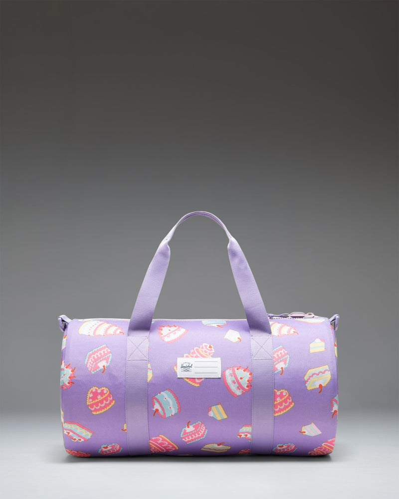 Herschel Supply Co. Classic Duffle Little Herschel in the playful Cakes print, showing its compact, kid-friendly design.