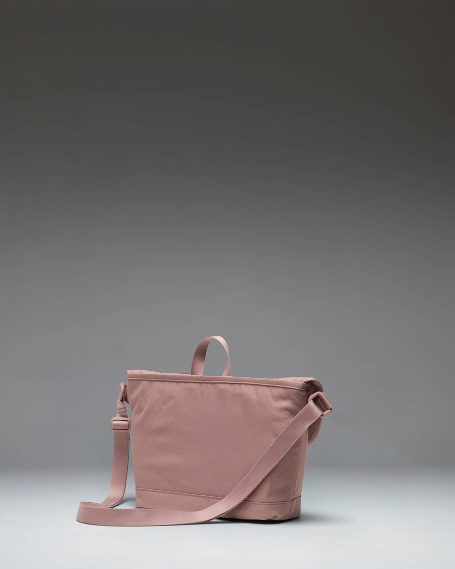 Herschel Supply Co Cove Small Messenger bag in Ash Rose pink, showing the front view with a flap closure, adjustable strap, and logo patch.