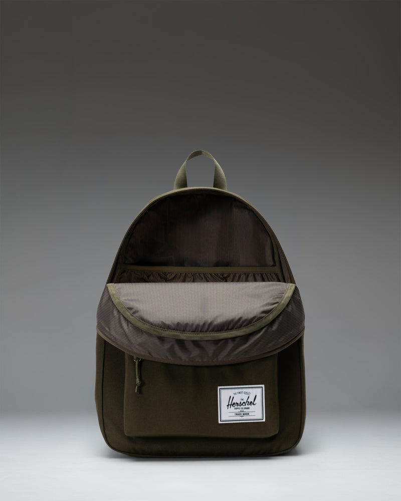 Herschel Supply Co. Classic Backpack in Ivy Green, showcasing its clean design, front pocket, and adjustable shoulder straps.