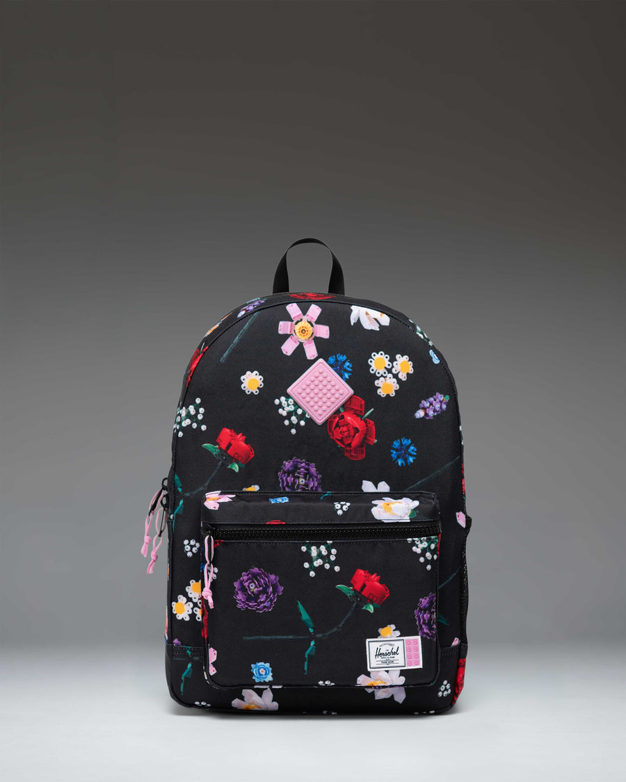 Herschel Supply Co. LEGO Heritage Youth Backpack in Falling Florals print, showing the front pocket with LEGO brick-inspired details.