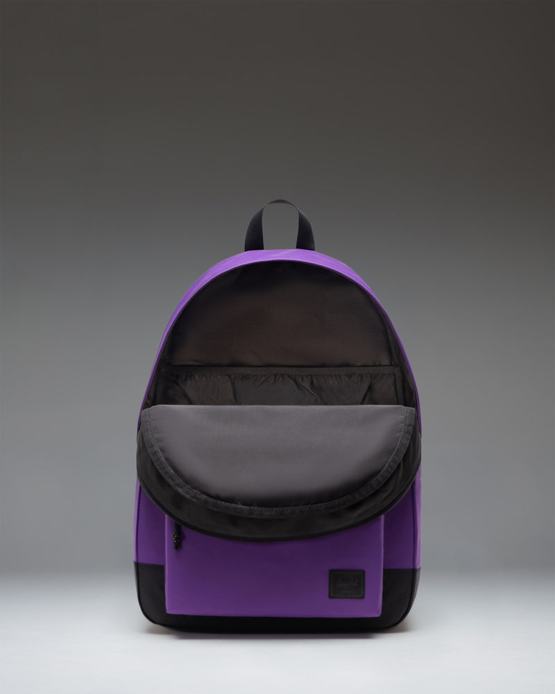 Herschel Supply Co. Classic XL Backpack in Acai purple, showing a front view with a spacious zippered pocket and iconic brand logo patch.