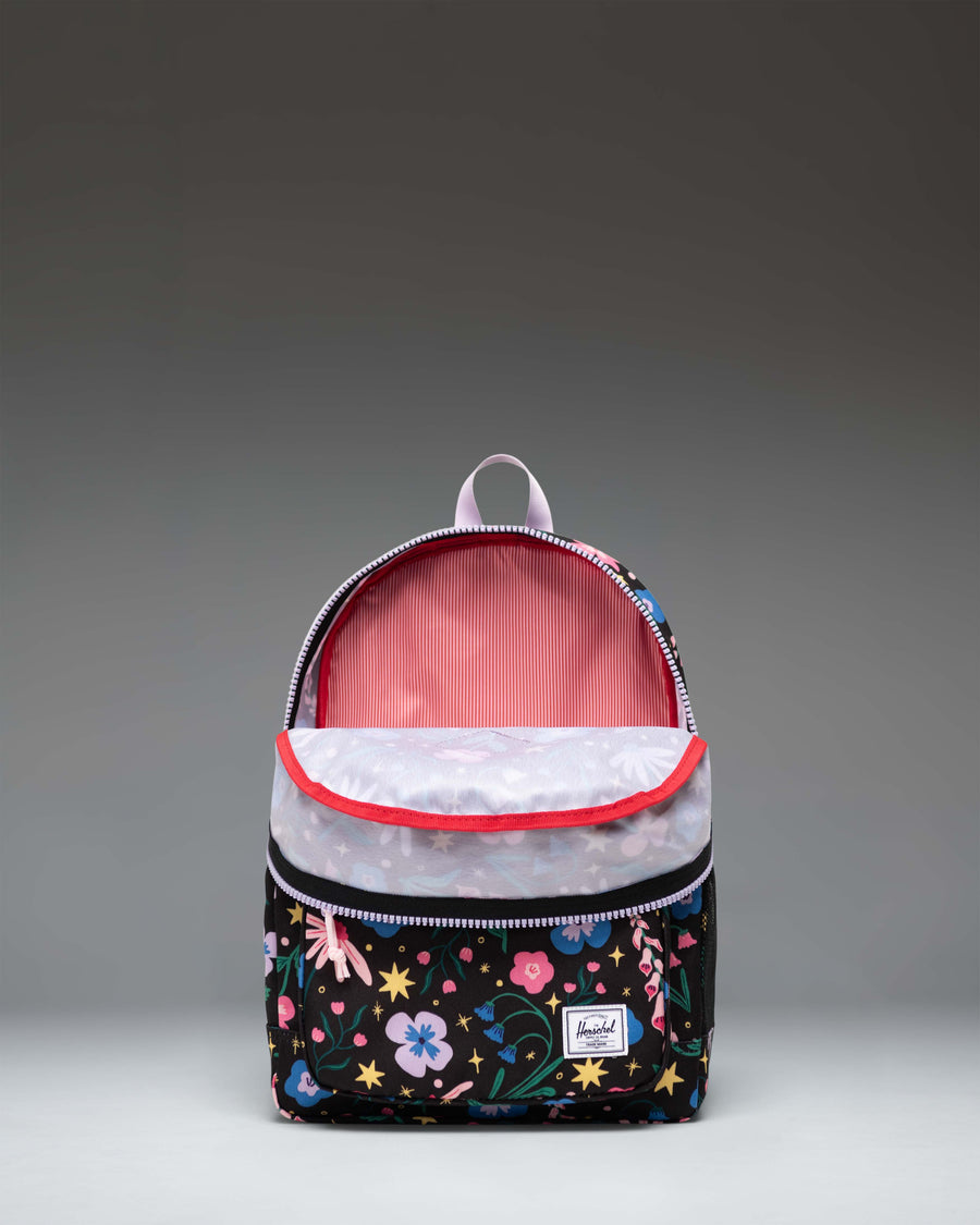Herschel Heritage Kids Backpack in Enchanted Garden, a dark backpack featuring a colorful floral pattern with pink, white, and blue flowers.