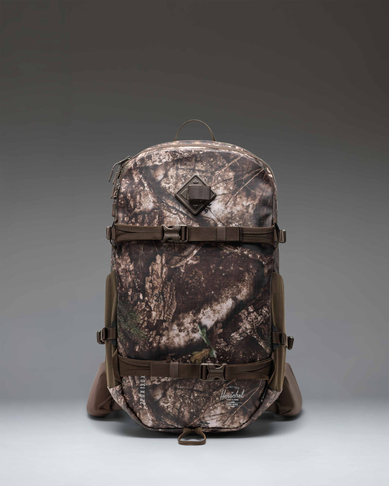 Herschel Supply Co. Realtree All Season Pro Backpack 36L in Realtree APX Camo pattern, showing a close-up of the outdoor hunting bag.