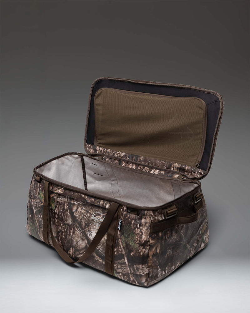 Herschel Supply Co. Realtree All Season Duffle 66 L in Realtree APX Camo pattern, showing a close-up of the durable fabric and camouflage details.