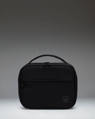 Herschel Supply Co. Pop Quiz Lunch Box in Black Tonal, showing the front view with a zippered pocket and top handle.