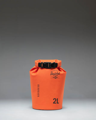 Herschel Supply Co. Dry Bag Organizer 2L in Vermillion Orange, showing a bright orange waterproof pouch with a roll-top closure.