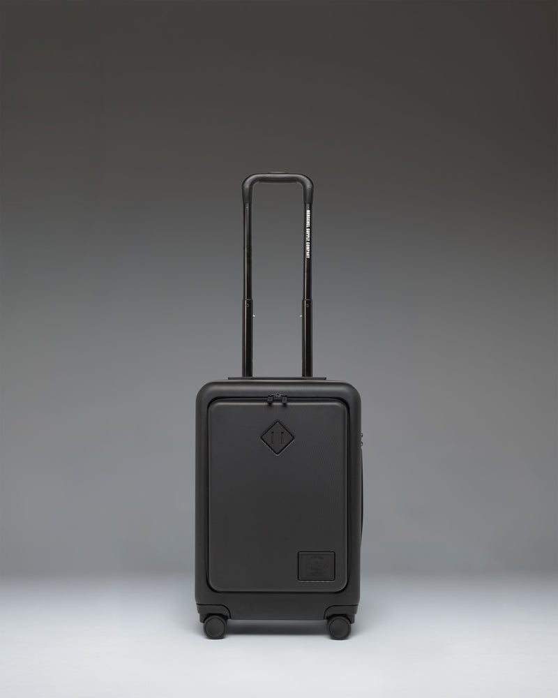 Herschel Supply Co. Herschel Heritage Hardshell Pro Large Carry On in black, showcasing its durable exterior, spinner wheels, and sleek design.