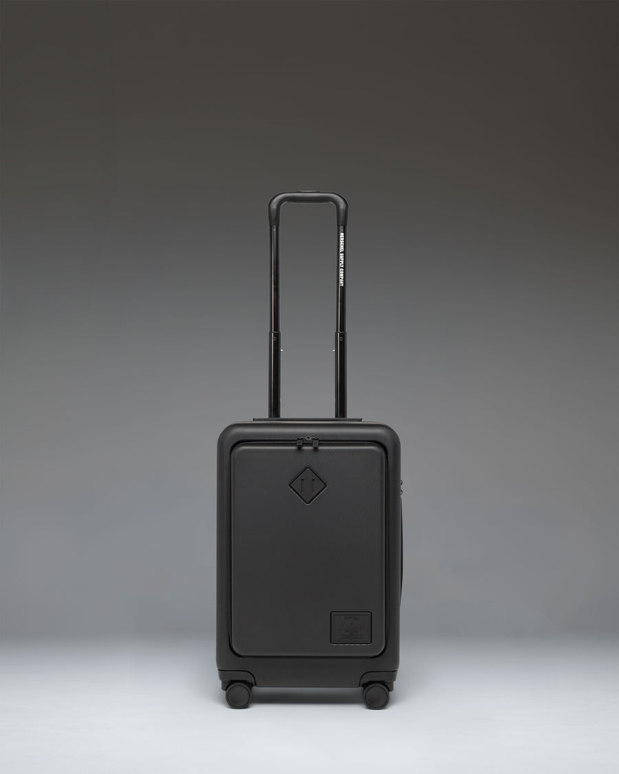 Herschel Supply Co. Herschel Heritage Hardshell Pro Large Carry On in black, showcasing its durable exterior, spinner wheels, and sleek design.