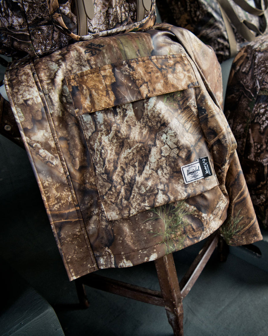 Herschel Supply Co. Men's Realtree Classic Rain Jacket in Realtree APX Camo, size guide chart showing sizing measurements.