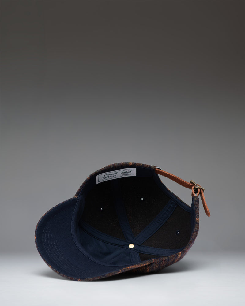 Dark Plaid and Tan Herschel Supply Co backpack lifestyle view showing the front, straps, and clean classic design.