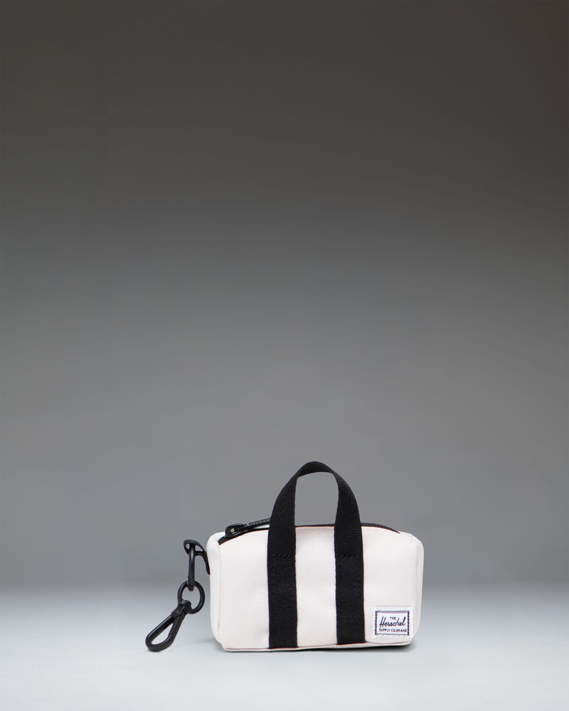 Herschel Novel Duffle Bag Charm in the light beige Moonbeam color, showing a miniature version of the classic duffle bag.