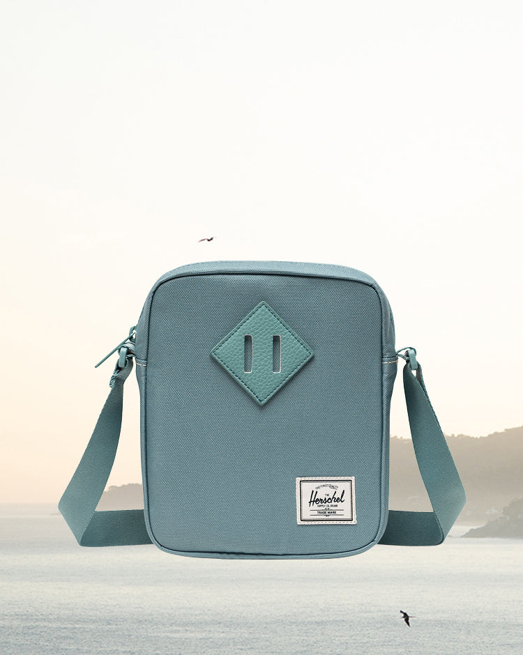 Herschel Heritage Crossbody bag in a sleek square-cut design with an adjustable shoulder strap and signature diamond detail.