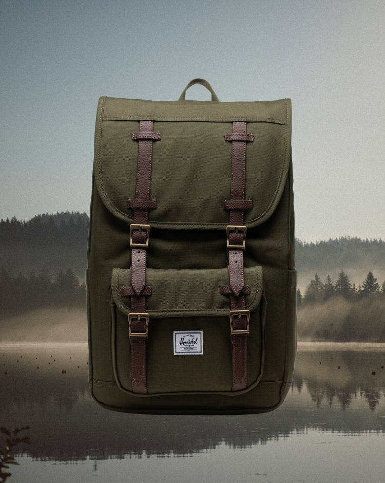 Herschel Supply Co. Herschel Little America Mid Backpack in Ivy Green featuring dual rubber straps, a front pocket, and woven brand label.