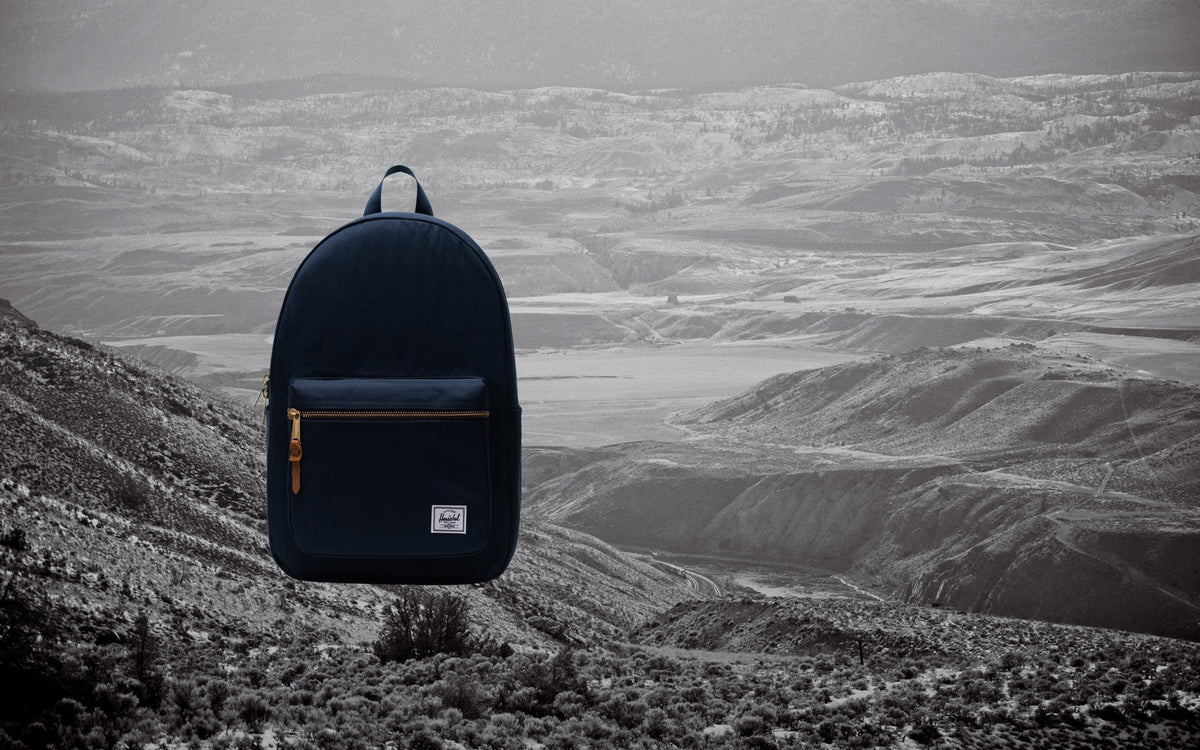 Herschel Supply Co. Settlement Backpack in navy blue, shown from the front on a clean background.