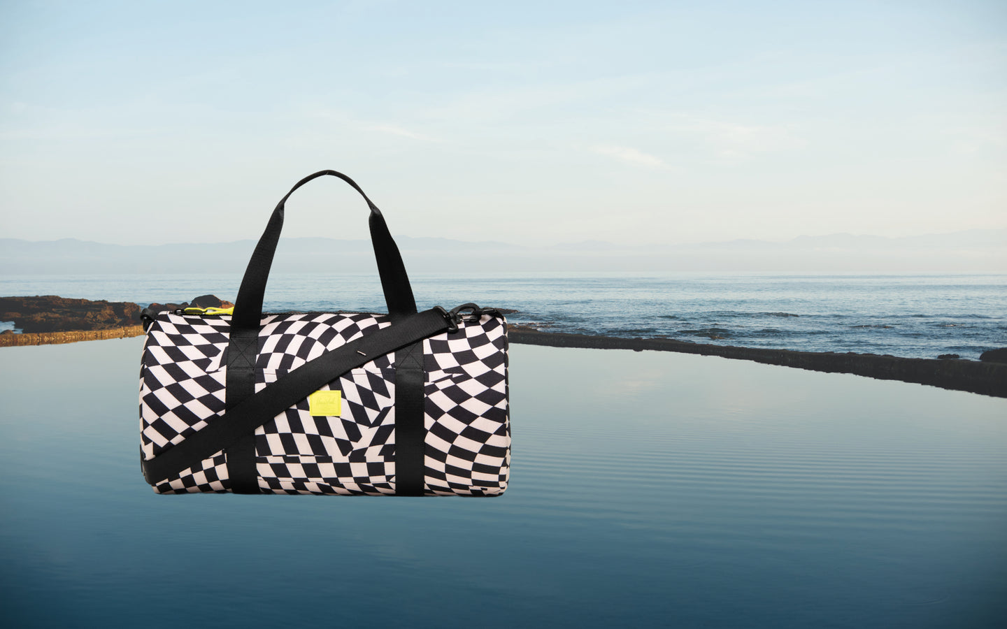Herschel Classic Duffle Little Herschel in Warp Check checkered pattern.