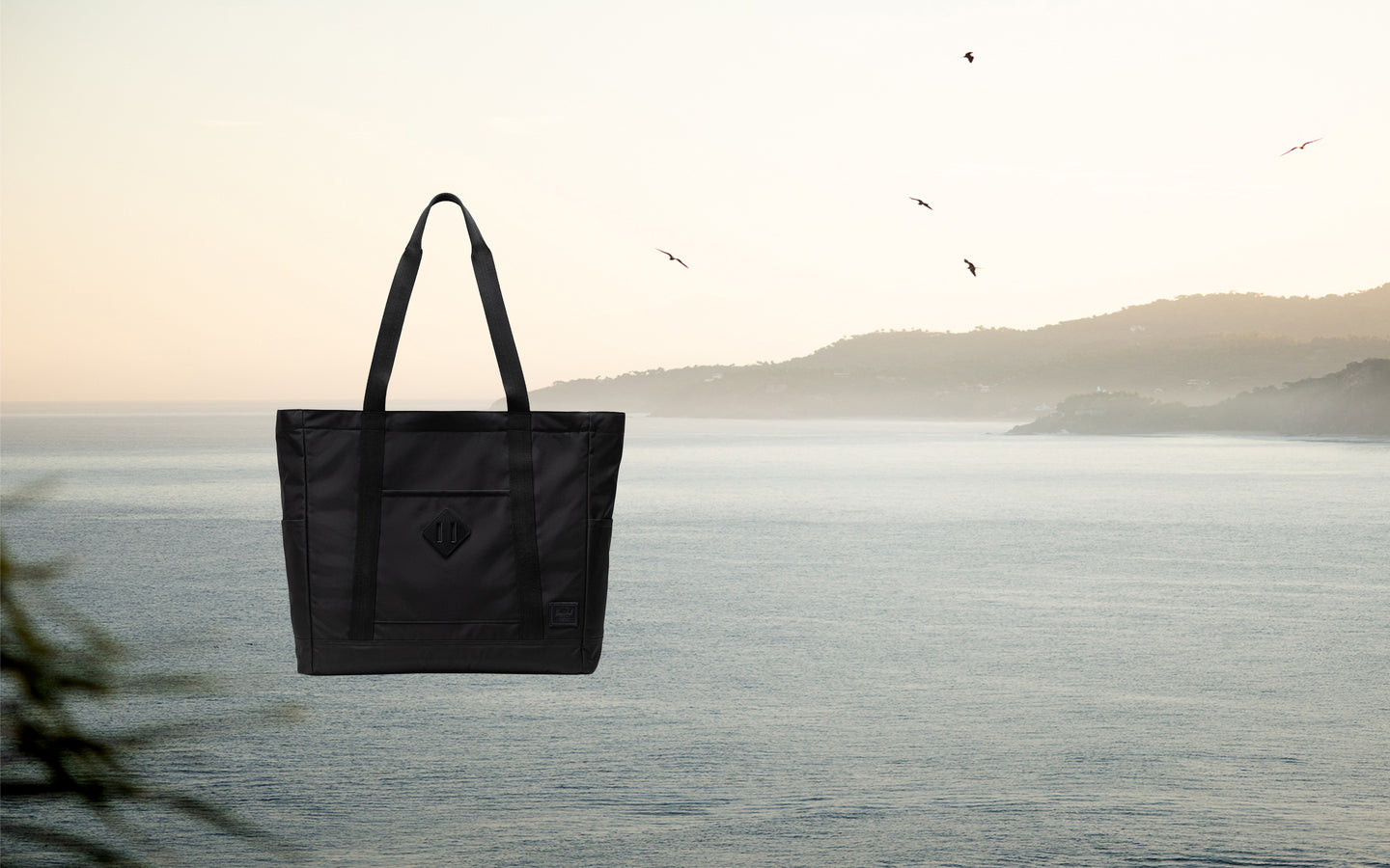 Herschel Heritage Tote bag in black shown on a desktop background display.