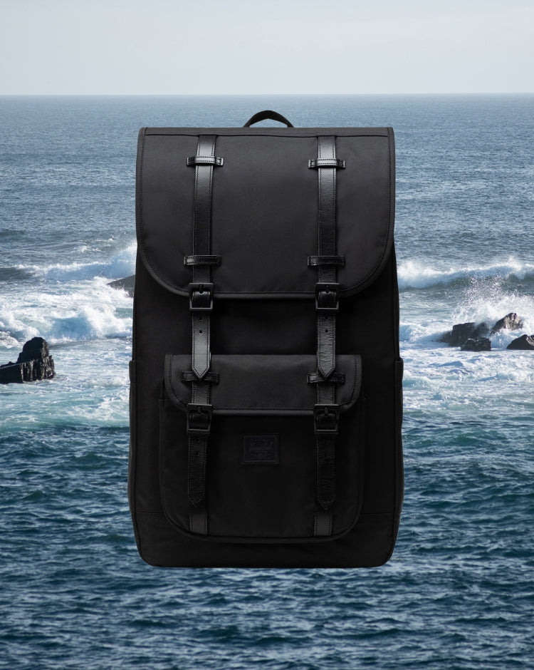Herschel Supply Co. Little America Backpack in black, featuring a classic mountaineering design with dual rubber straps and front pocket.