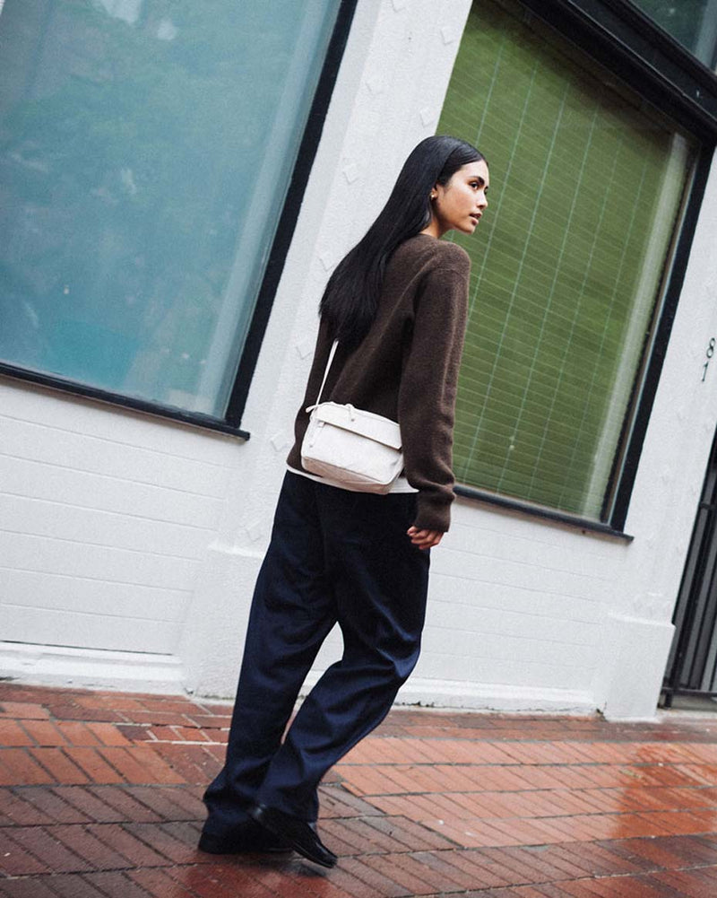 Herschel Supply Co. Alberni Crossbody bag in Moonbeam cream-white color with an adjustable shoulder strap and water-resistant finish.