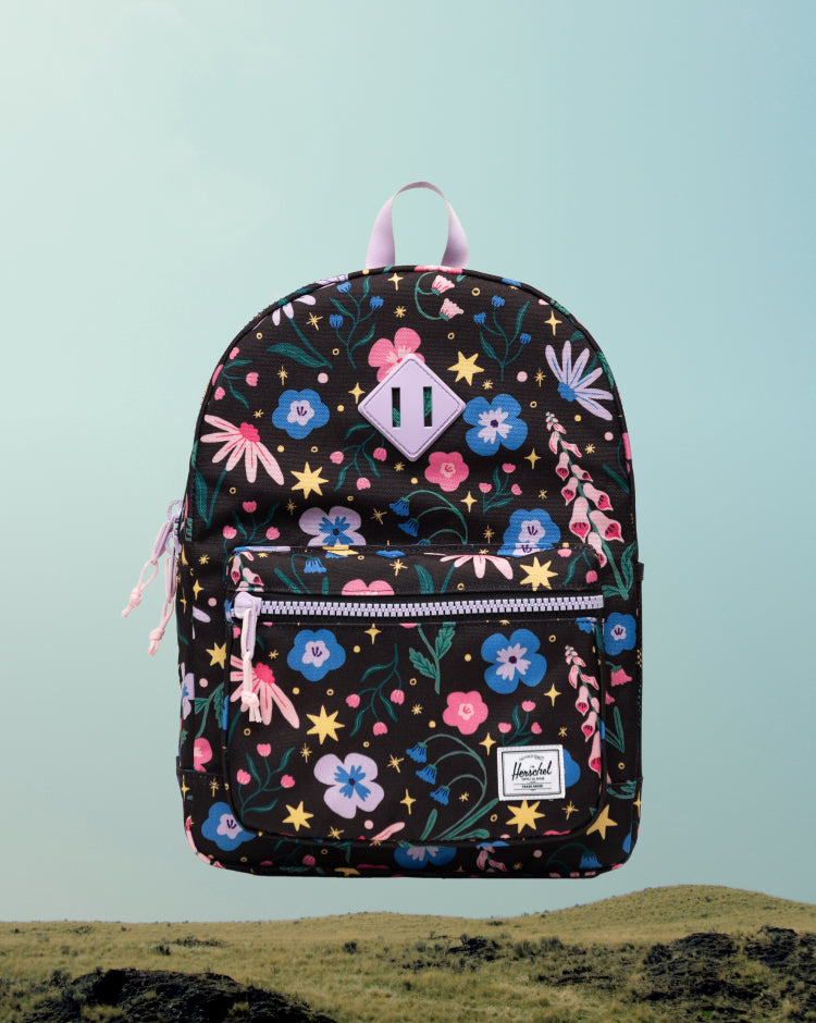Herschel Heritage Kids Backpack in Enchanted Garden, a floral pattern with pink and blue flowers on a dark background.