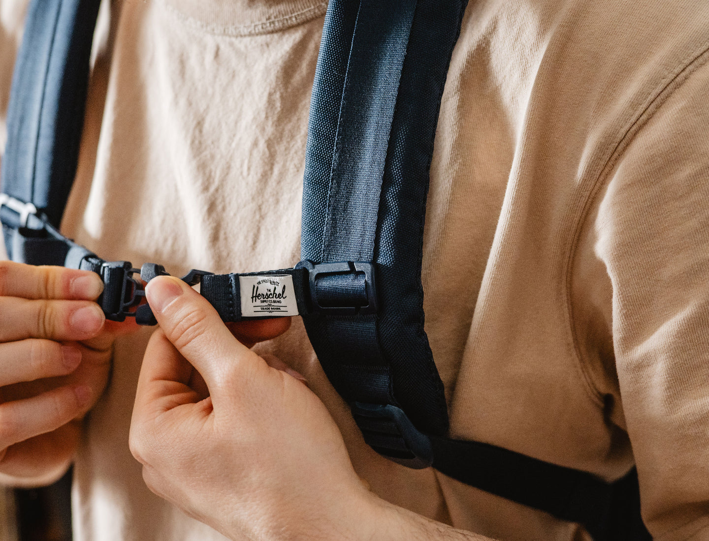 Herschel Supply Co. adjustable navy blue sternum strap with a black side-release buckle on a clean background.