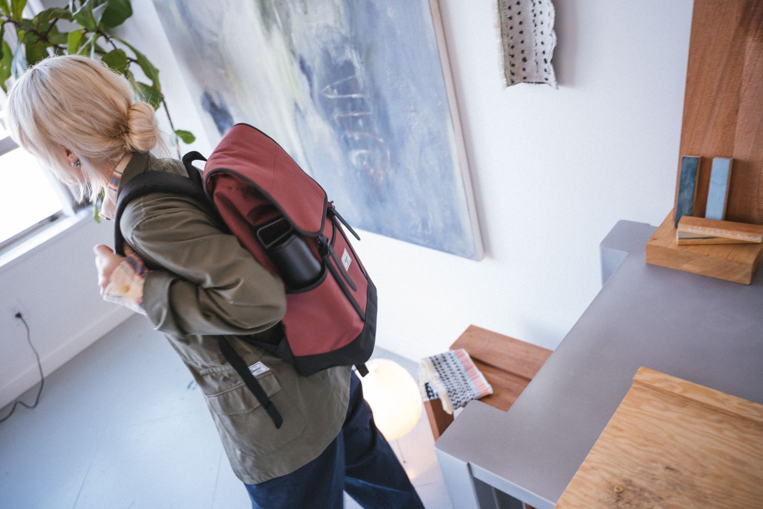 A person walking away from their desk with their Herschel Retreat Backpack Pro on their back.