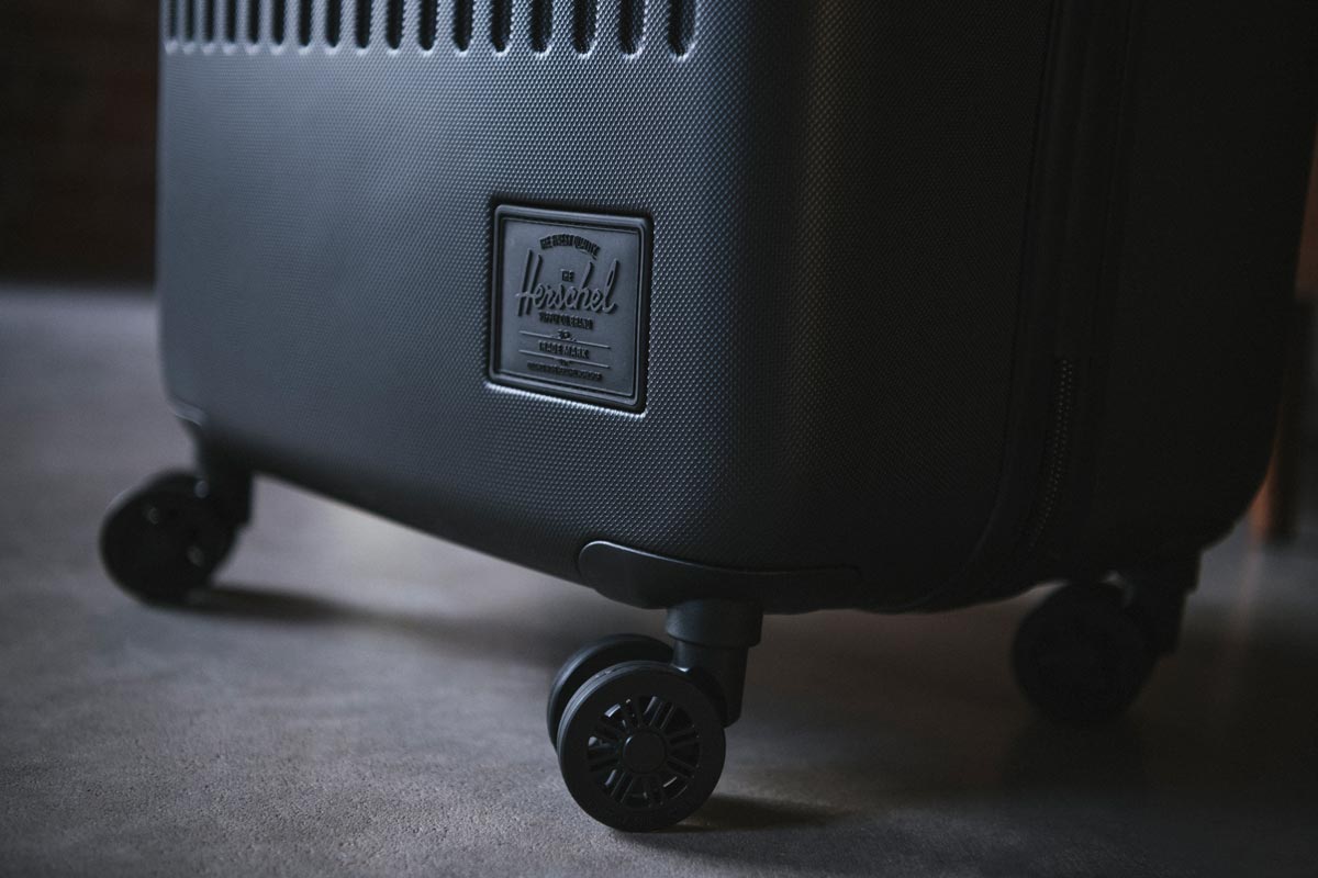 A Herschel Trade Luggage Carry-On suitcase wheel that spins 360°